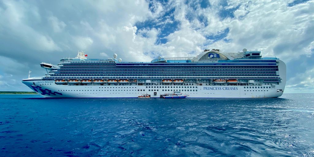 sailing white and blue cruise ship under cloudy sky