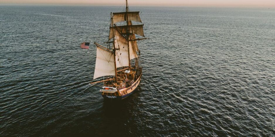 brown sailboat in beach under white sky
