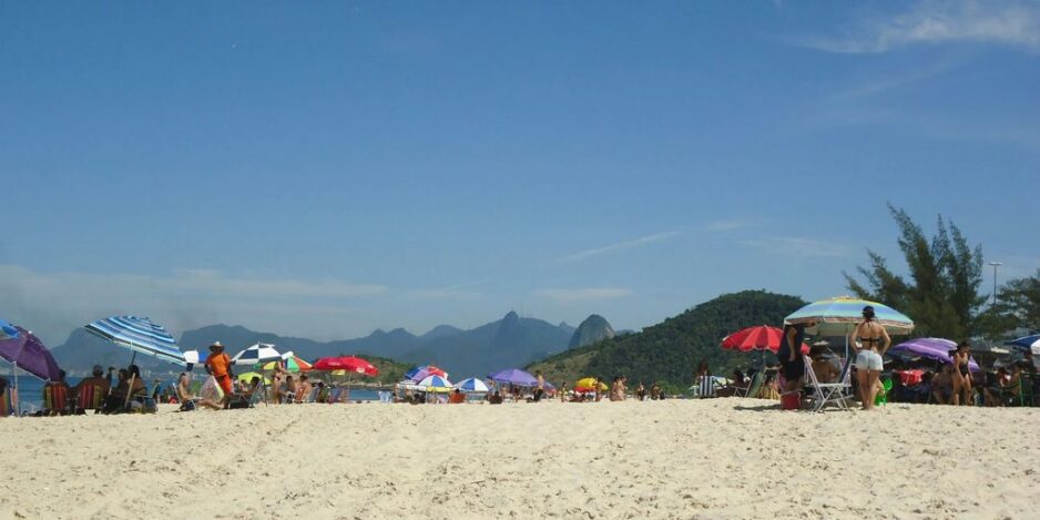 a group of people standing on top of a sandy beach