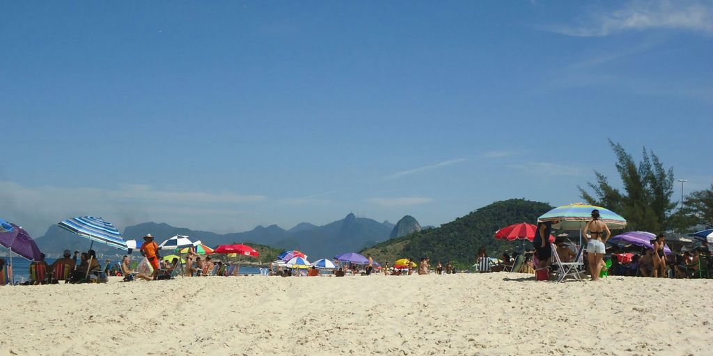 a group of people standing on top of a sandy beach