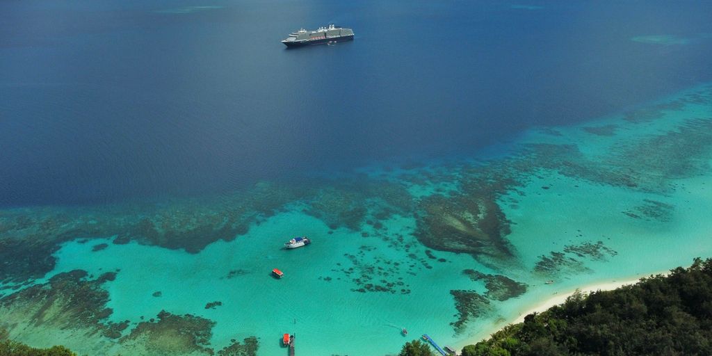 a cruise ship is in the water off the coast of a tropical island