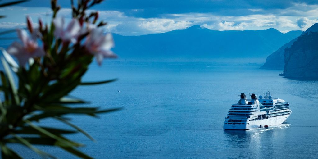 white ship on sea under blue sky and white clouds during daytime