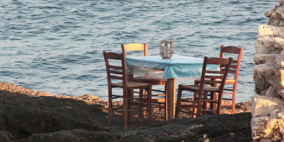 a table and chairs sitting on a rocky shore